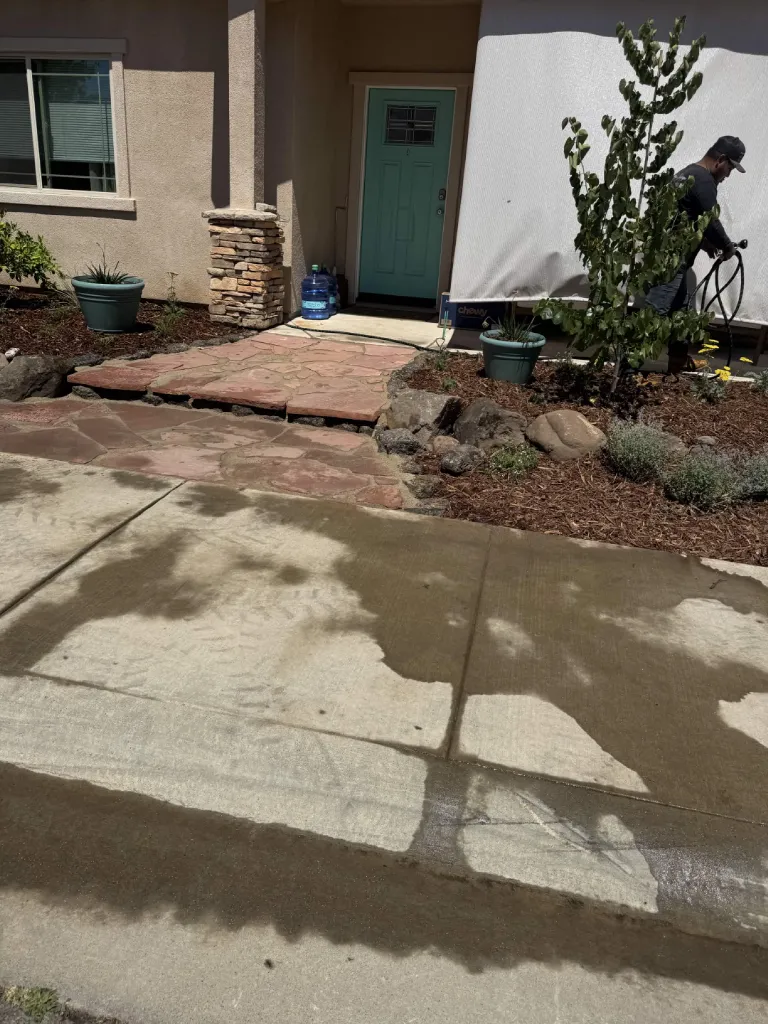 Flagstone walkway leading to a front entry with stacked stone column and mulched beds