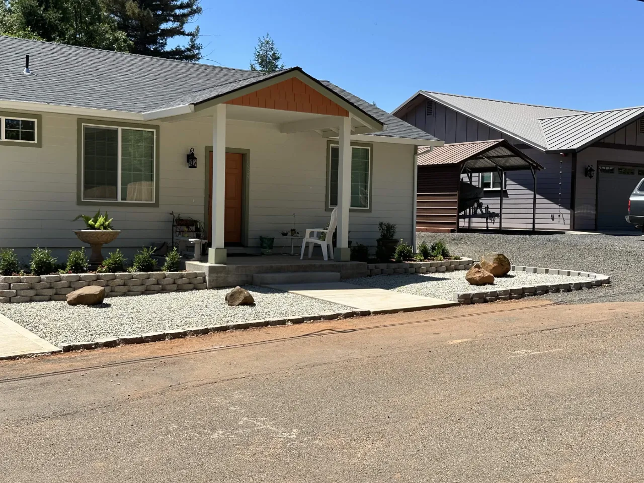 Front yard with retaining walls, white gravel beds and accent boulders