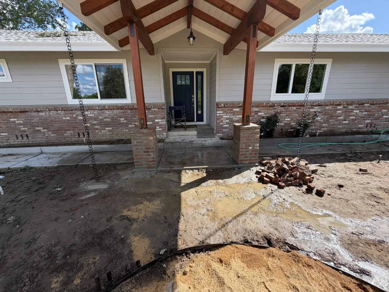 Front porch hardscape construction with brick columns and exposed beams