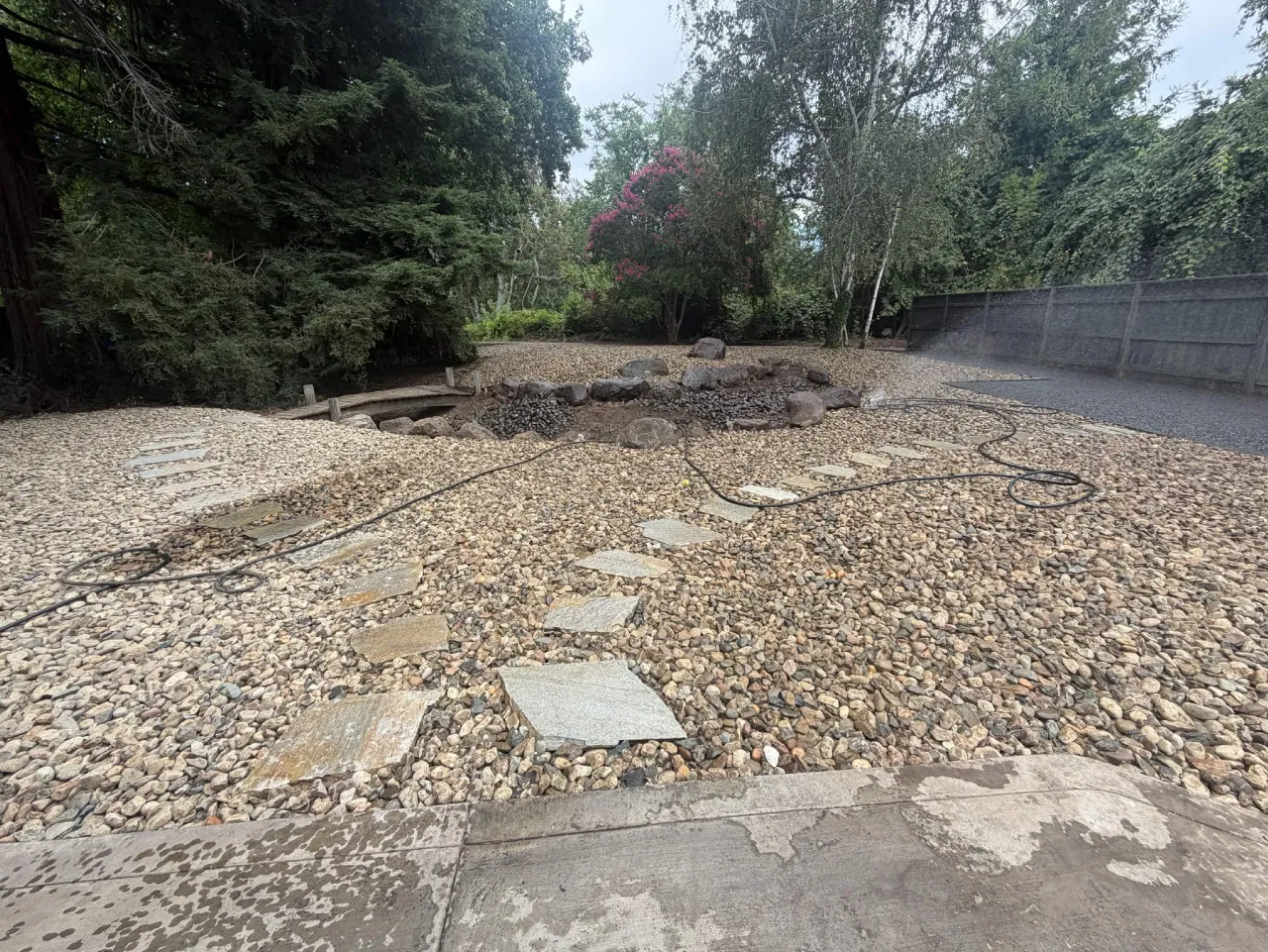 Flagstone stepping stone path set in river rock with a boulder-lined dry creek bed