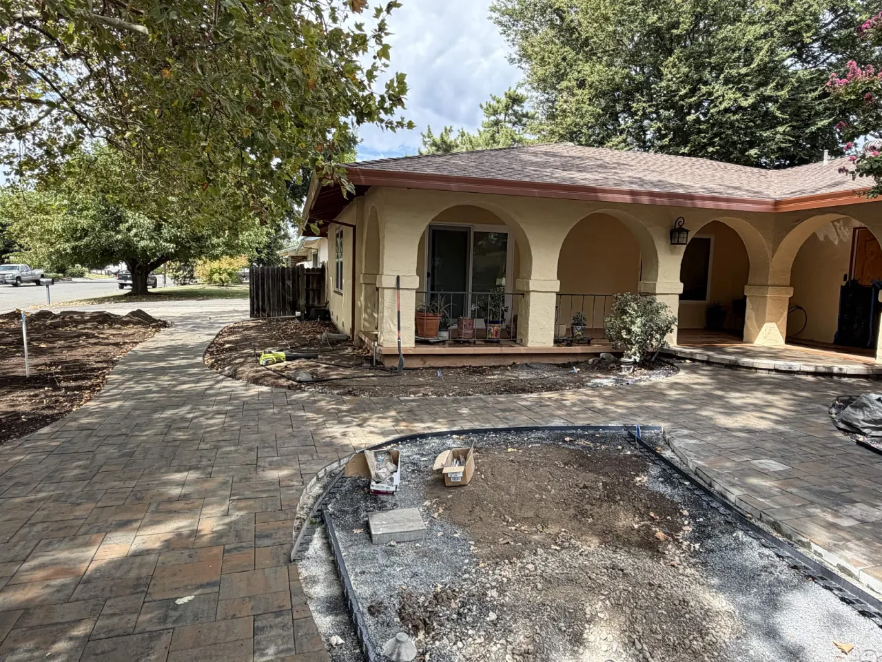 Front entry paver driveway and walkway installation at a stucco home with arched porch
