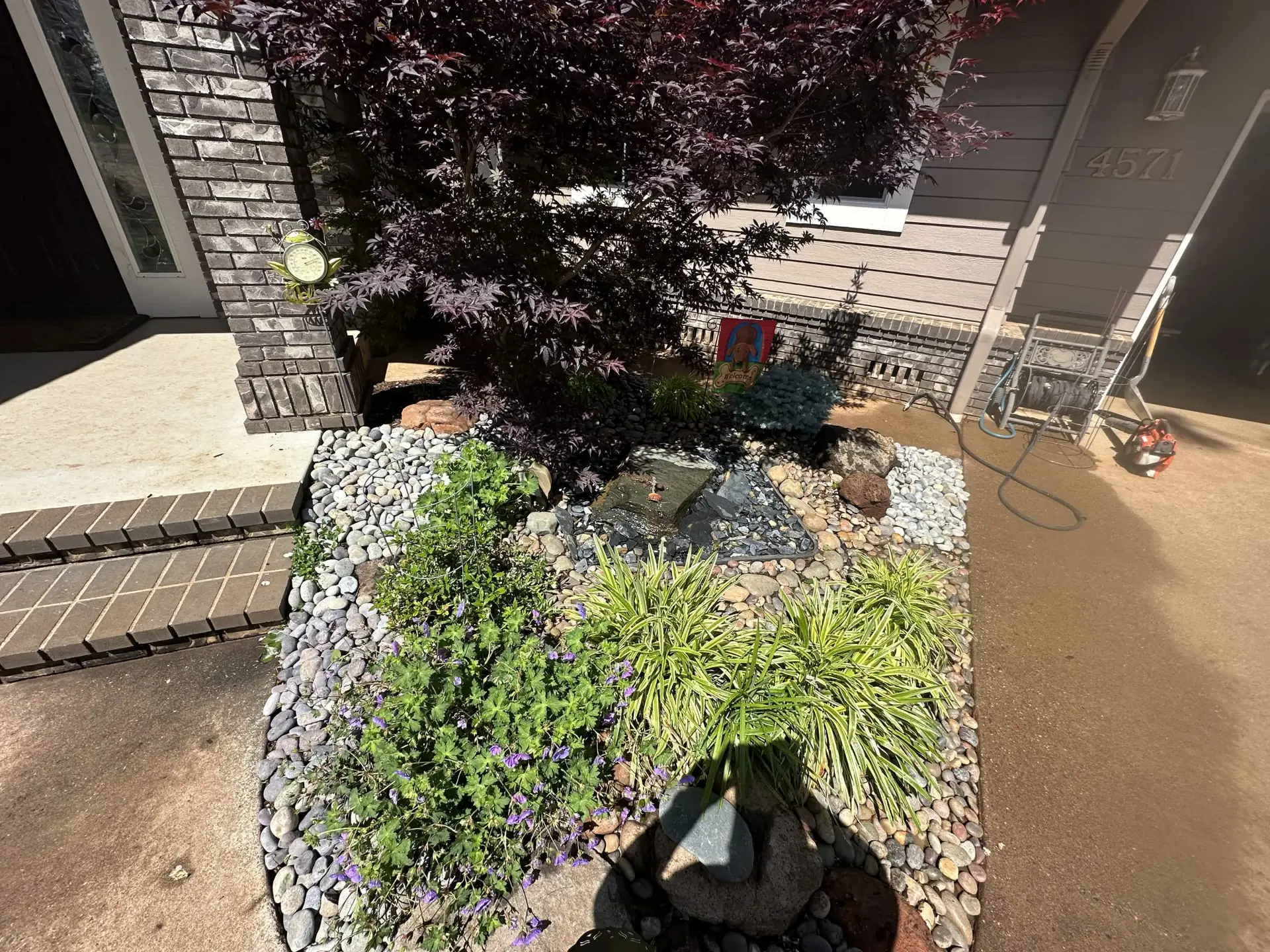 Entry garden with a bubbling rock water feature, river rock and low-water plantings