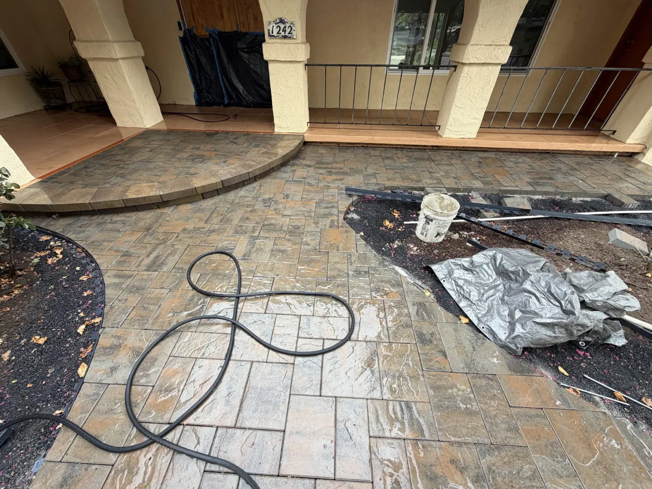 Wide paver courtyard with curved rock border beds in progress