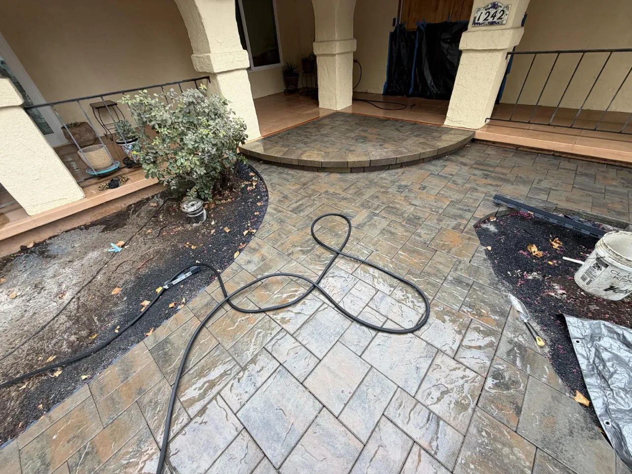 Freshly installed paver patio with rounded step and planter beds