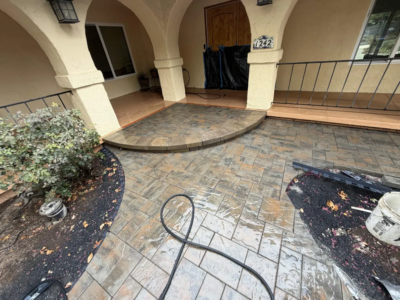 Curved paver step and patio installed at an arched front porch